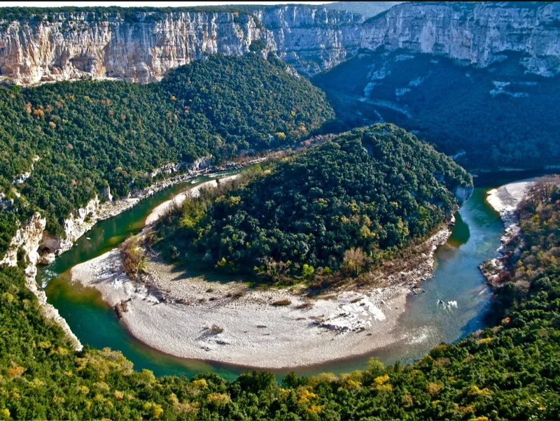 Un méandre des Gorges de l'Ardèche vu d'un belvédère, entre falaises calcaires et forêt