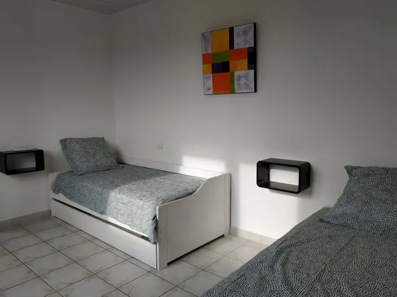 Deux lits simples côte à côte dans une chambre claire