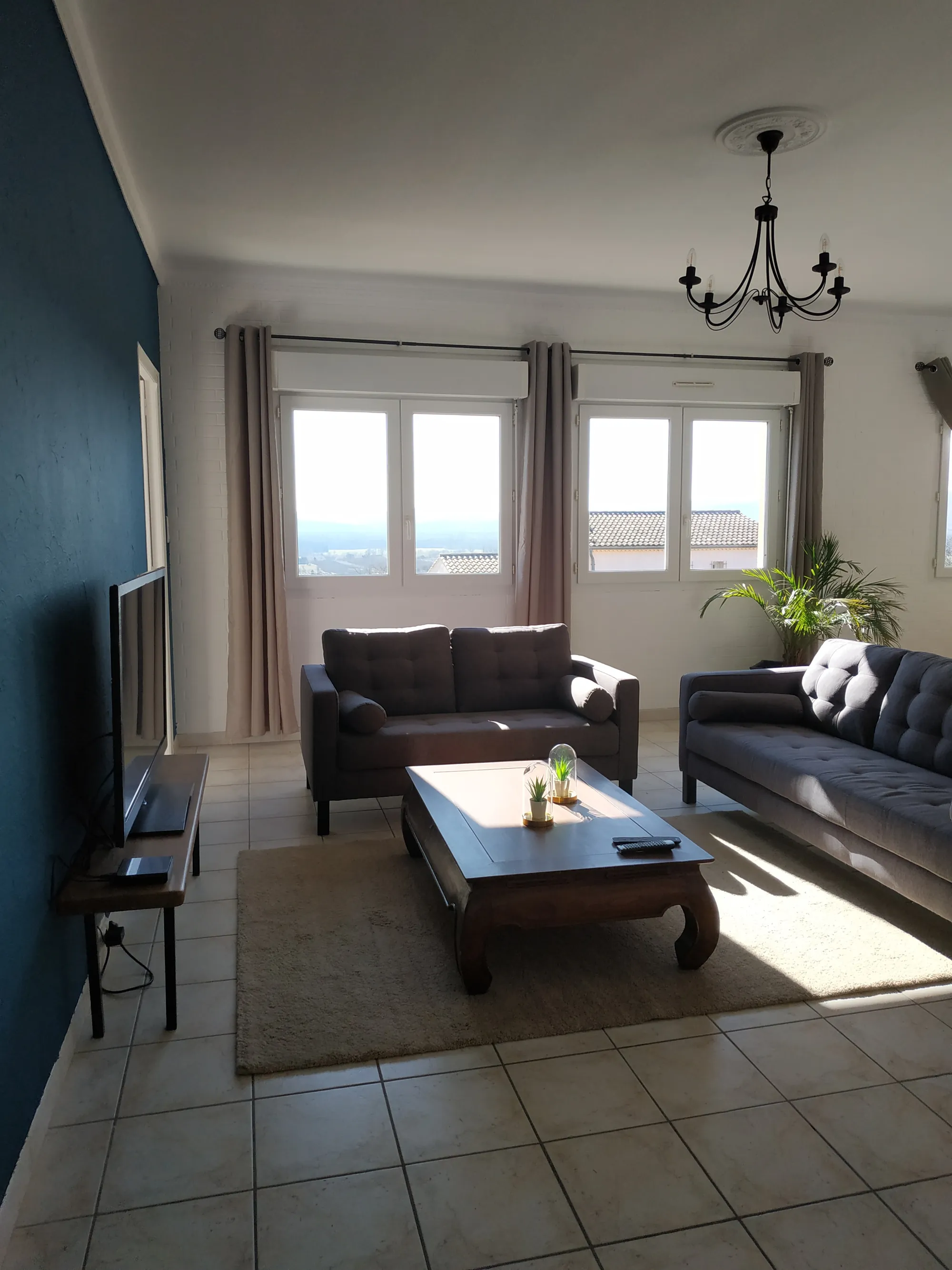 Le salon vu de l'autre côté, avec les grandes fenêtres et la vue sur la vallée